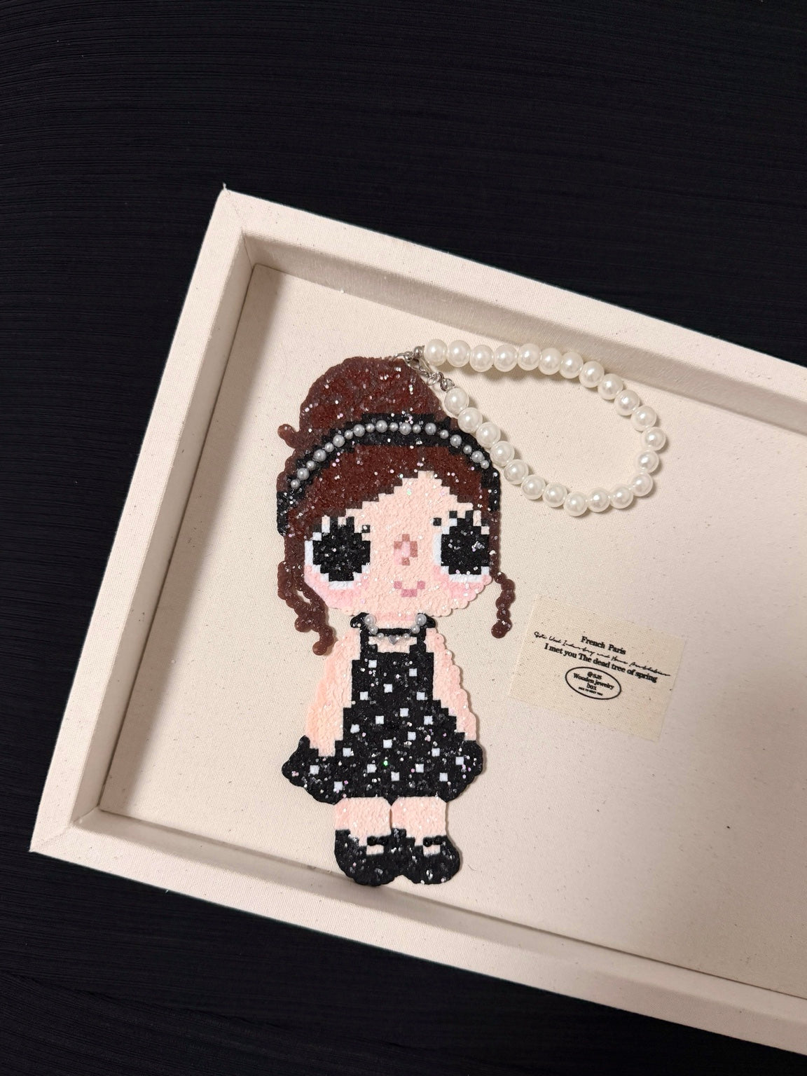 Handmade pixel bead charm featuring a girl in a sparkling black dress