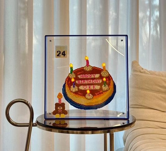 Handmade light-up birthday cake pixel bead frame displayed on a side table