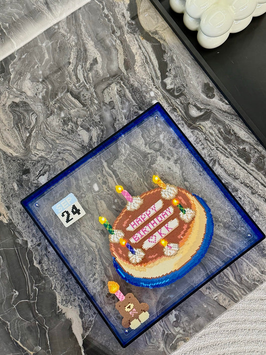 Top-down view of handmade light-up birthday cake pixel bead frame