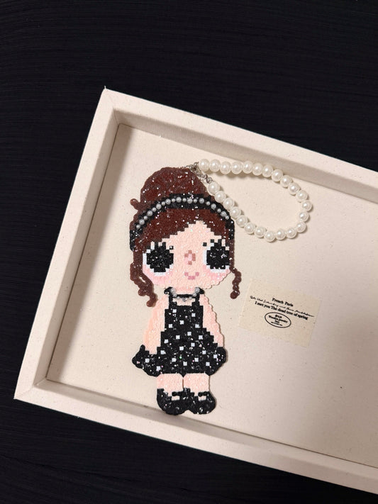 Handmade pixel bead charm featuring a girl in a sparkling black dress