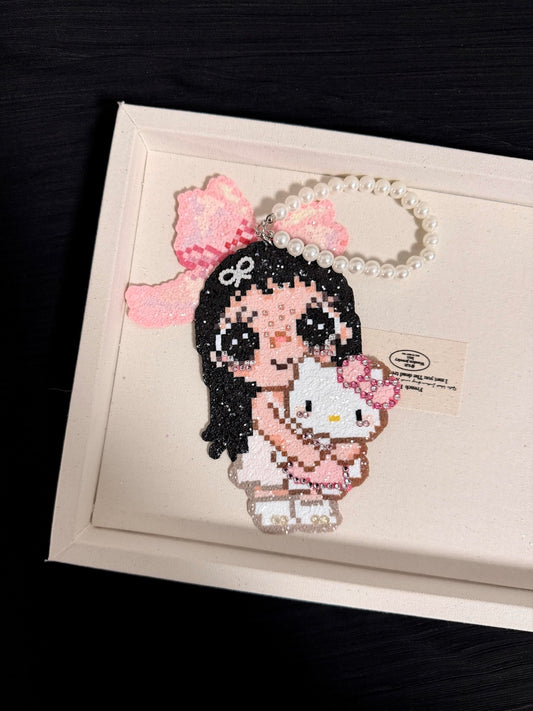 Handmade pixel bead charm featuring a pink bow girl holding a white kitty