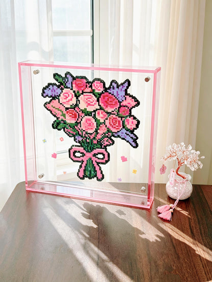 Pink rose bouquet pixel bead acrylic frame displayed by a sunny window