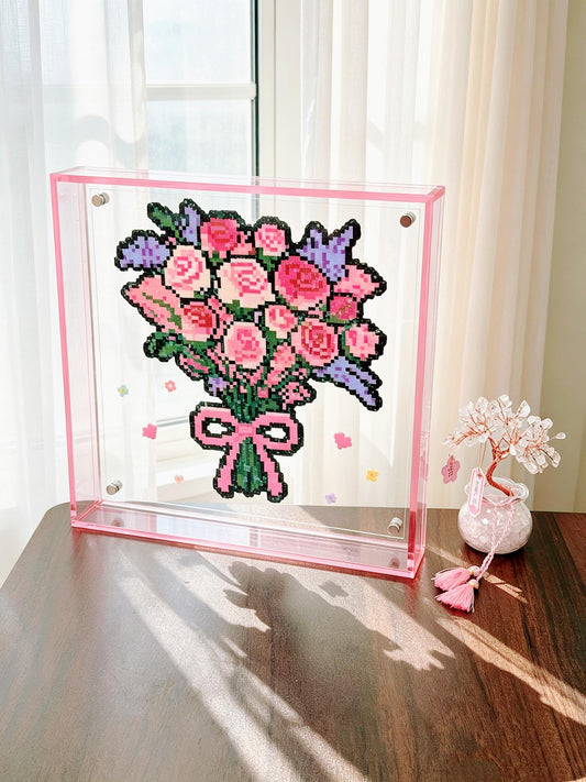 Pink rose bouquet pixel bead acrylic frame displayed by a sunny window